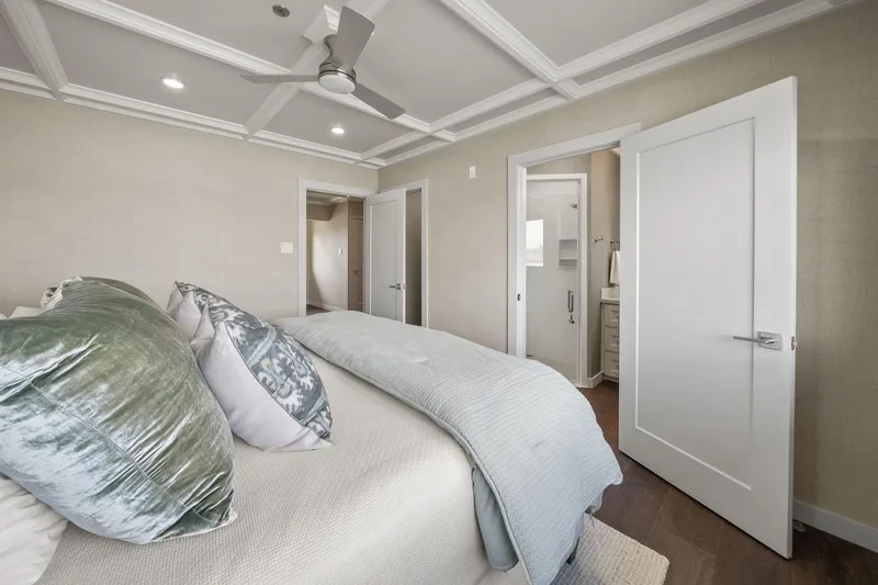 Shine Down Yacht Photos Pics Luxurious bedroom interior with plush pillows, modern ceiling fan, and en-suite bathroom, Breaux Brothers 120 GLV.