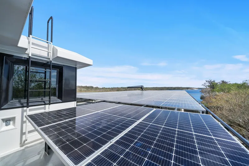 Shine Down Yacht Photos Pics Solar panels on Breaux Brothers 120 GLV boat, 2025 model, near a serene waterway.