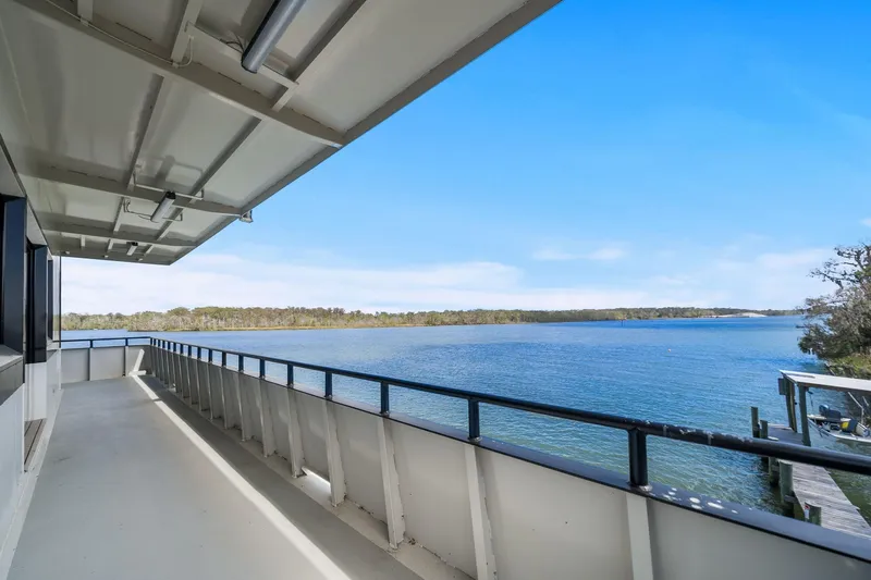 Shine Down Yacht Photos Pics Deck view from Breaux Brothers 120 GLV yacht, overlooking serene waters and distant shoreline.