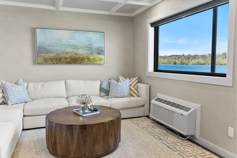 Shine Down Yacht Photos Pics Modern living room with lake view, featuring a cozy white sofa and wooden coffee table.