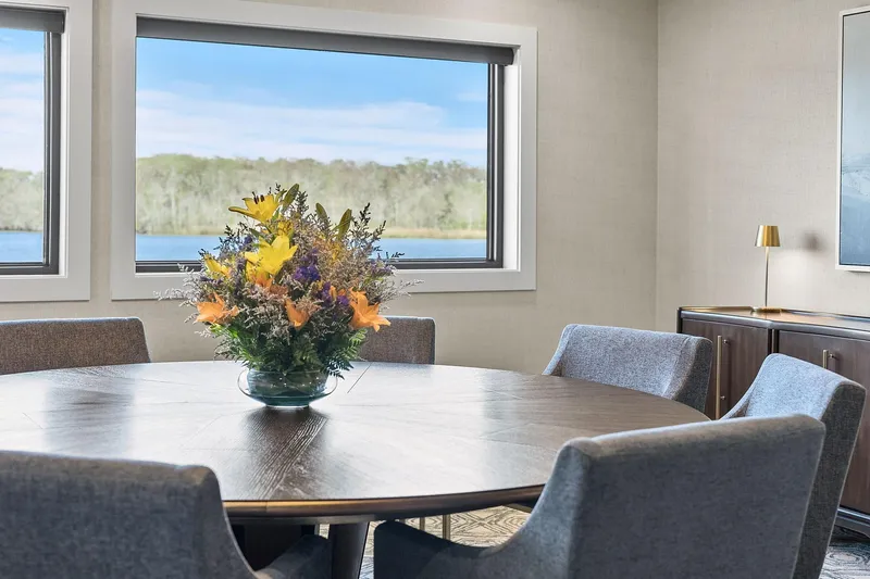 Shine Down Yacht Photos Pics Elegant dining area on Breaux Brothers 120 GLV yacht, featuring floral centerpiece and scenic window view.