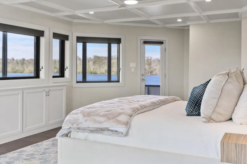 Shine Down Yacht Photos Pics Luxurious bedroom interior on Breaux Brothers 120 GLV yacht, featuring panoramic windows and elegant decor.