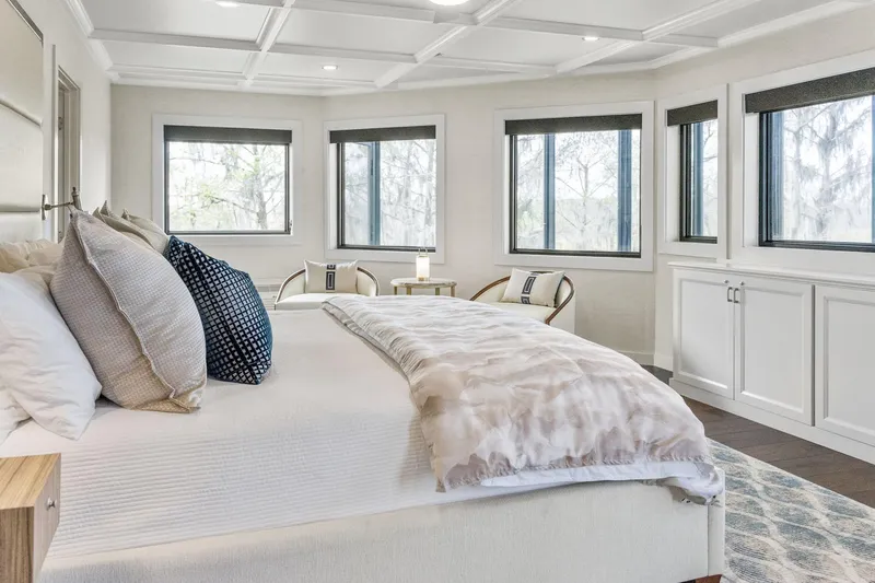 Shine Down Yacht Photos Pics Luxurious bedroom interior with large windows, elegant bedding, and modern decor on a Breaux Brothers 120 GLV.