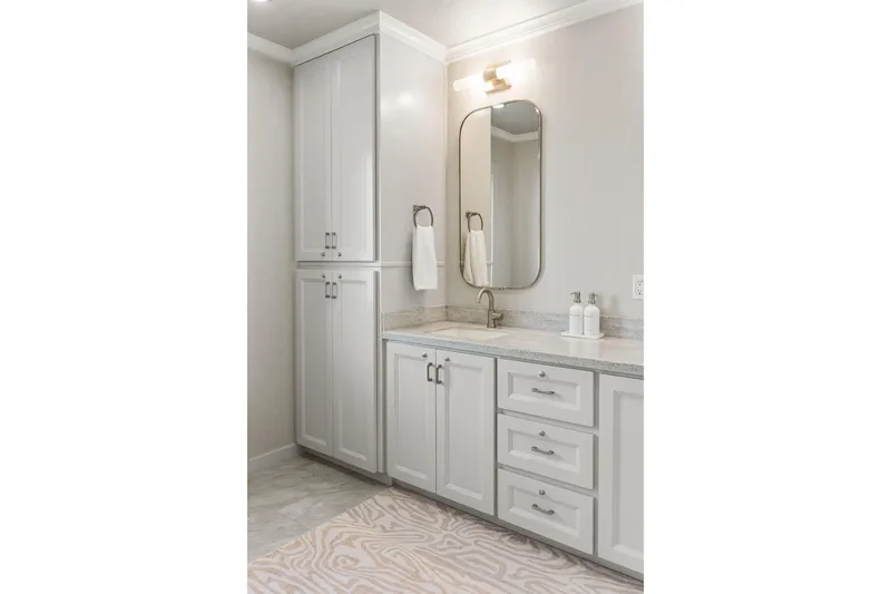 Shine Down Yacht Photos Pics Modern bathroom with white cabinetry, sleek mirror, and elegant lighting.
