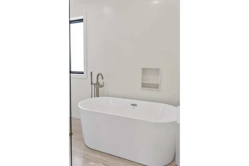 Shine Down Yacht Photos Pics Modern bathroom with a sleek freestanding bathtub and minimalist design, featuring a wall niche.