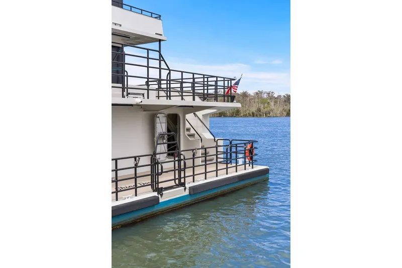 Shine Down Yacht Photos Pics Breaux Brothers 120 GLV boat, 2025 model, docked on a serene lake with railing.