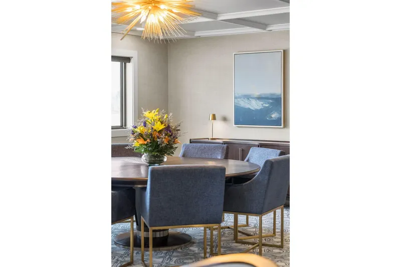 Shine Down Yacht Photos Pics Elegant dining room with blue chairs, floral centerpiece, and modern artwork. Breaux Brothers 120 GLV 2025.