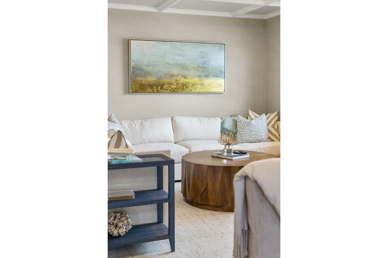 Shine Down Yacht Photos Pics Modern living room with white sectional, wooden coffee table, and abstract wall art.