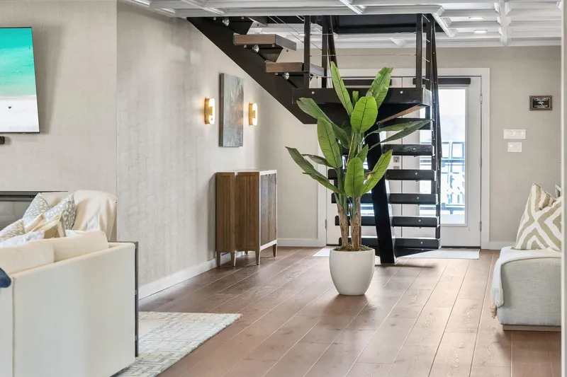 Shine Down Yacht Photos Pics Modern living room with sleek staircase, potted plant, and stylish decor.