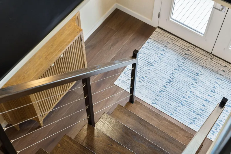 Shine Down Yacht Photos Pics Staircase with wooden steps, modern railing, and patterned rug in a stylish interior.