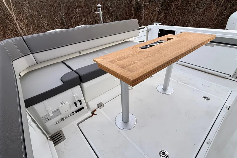  Yacht Photos Pics 2022 Jeanneau Leader 9.0 CC boat interior with seating and wooden table.