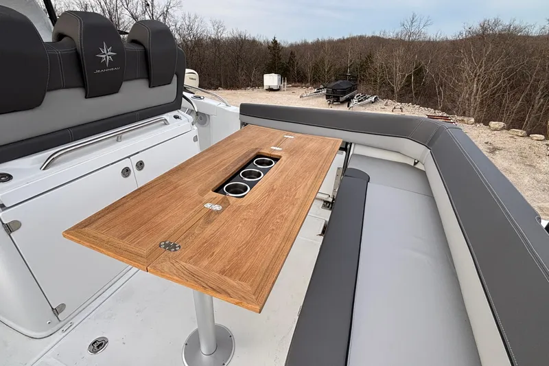  Yacht Photos Pics 2022 Jeanneau Leader 9.0 CC boat interior with wooden table and cushioned seating.