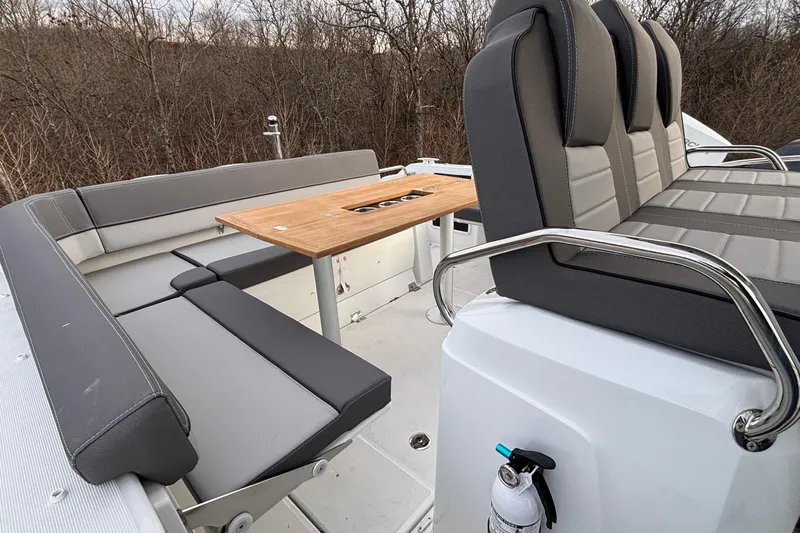  Yacht Photos Pics 2022 Jeanneau Leader 9.0 CC boat interior with gray seating and wooden table.
