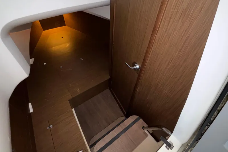  Yacht Photos Pics 2022 Jeanneau Leader 9.0 CC cabin interior with wooden flooring and door.