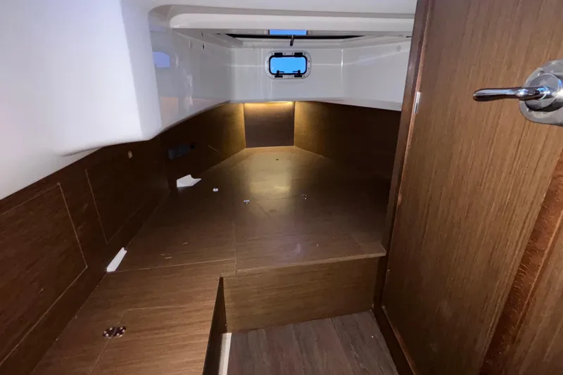  Yacht Photos Pics 2022 Jeanneau Leader 9.0 CC cabin interior with wood finish and porthole window.