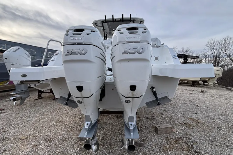  Yacht Photos Pics 2022 Jeanneau Leader 9.0 CC with twin 350 horsepower outboard engines, parked on gravel.