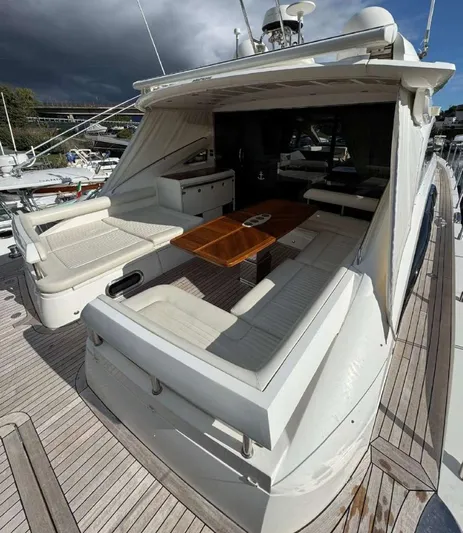 Yacht Photos Pics 2008 Princess V65 yacht with spacious deck, elegant seating, and wooden table under cloudy skies.