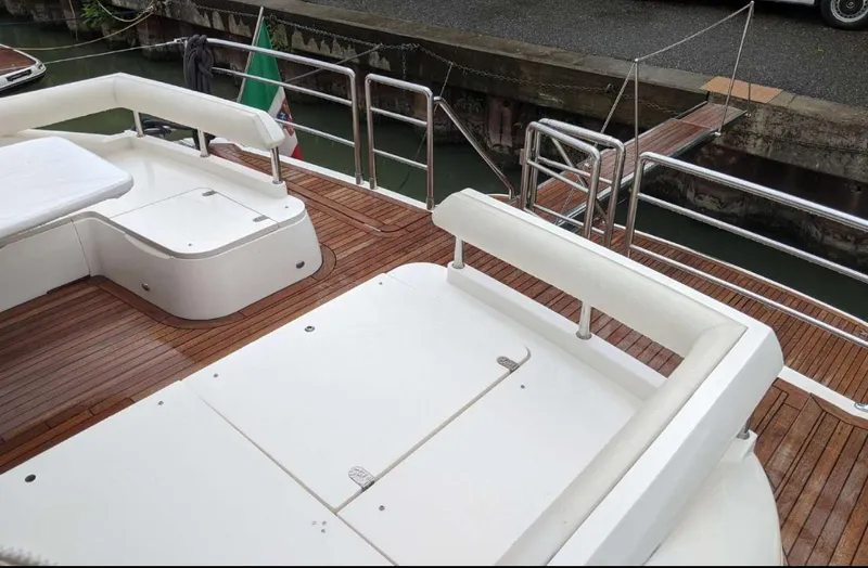  Yacht Photos Pics 2008 Princess V65 yacht deck with wooden flooring and white seating, docked by the water.
