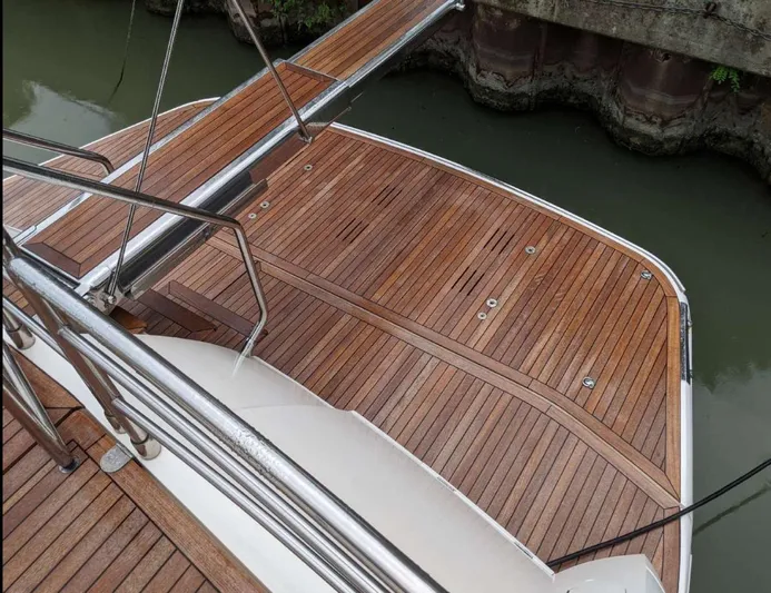  Yacht Photos Pics Teak deck of 2008 Princess V65 yacht, featuring elegant wood finish and stainless steel railings.