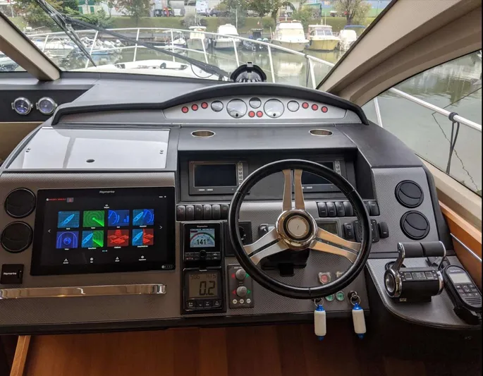  Yacht Photos Pics Cockpit of 2008 Princess V65 yacht with modern navigation controls and steering wheel.