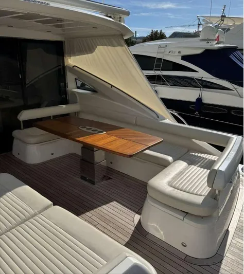  Yacht Photos Pics Luxury seating area on 2008 Princess V65 yacht with wooden table and cushioned benches.