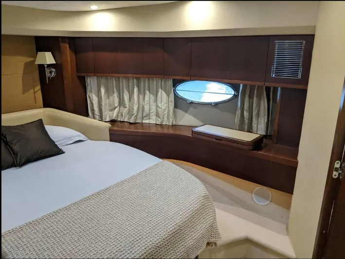  Yacht Photos Pics Luxurious bedroom interior of 2008 Princess V65 yacht with elegant wood finishes and porthole window.