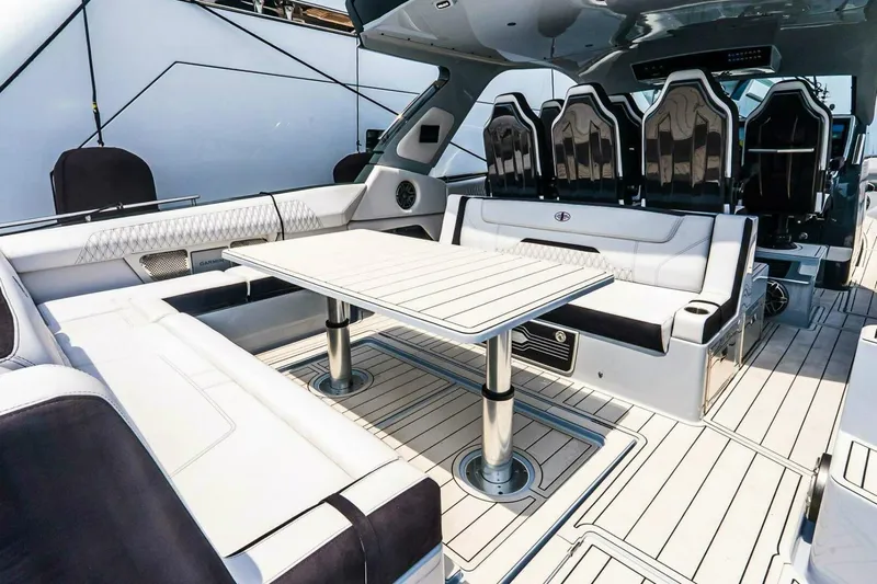  Yacht Photos Pics Luxurious interior of 2025 Cigarette 52' Thunder yacht with sleek seating and table.