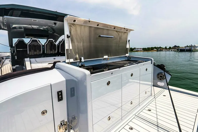  Yacht Photos Pics 2025 Cigarette 52' Thunder yacht with open deck storage, docked by the water.