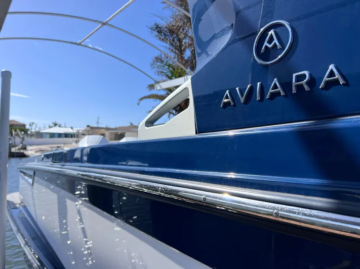 Impulse Yacht Photos Pics Close-up of 2022 Aviara AV 32 Outboard boat, showcasing sleek blue design and logo.