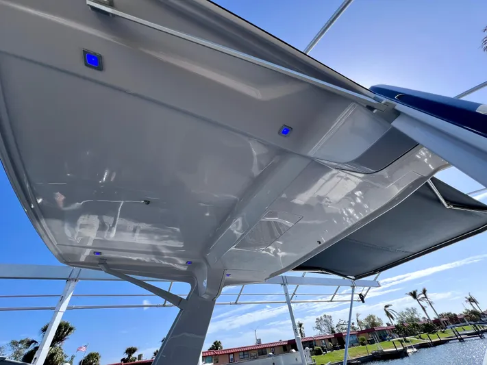 Impulse Yacht Photos Pics Aviara AV 32 Outboard 2022 boat canopy with blue LED lights, clear sky background.
