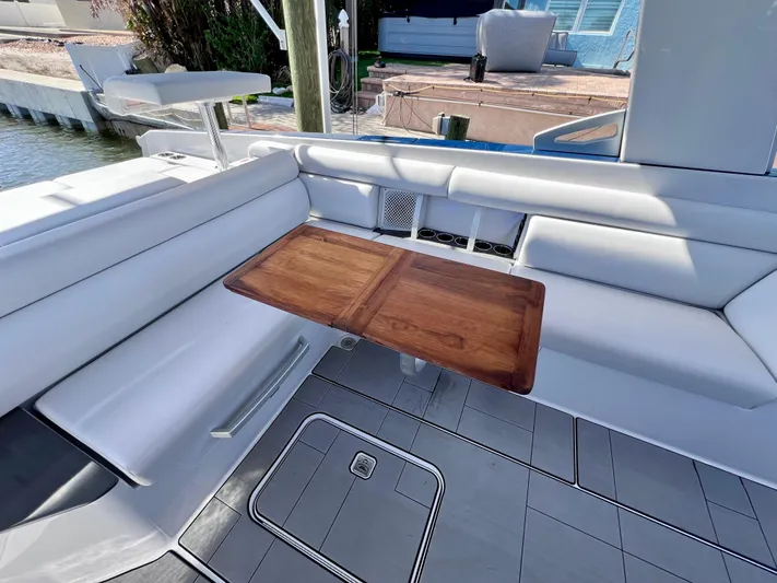 Impulse Yacht Photos Pics 2022 Aviara AV 32 Outboard boat interior with sleek seating and wooden table.