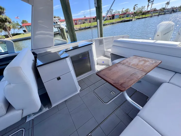 Impulse Yacht Photos Pics Luxurious 2022 Aviara AV 32 Outboard boat interior with seating and table by the water.