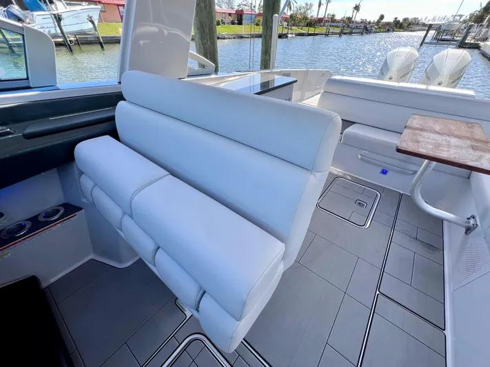 Impulse Yacht Photos Pics Luxurious seating on 2022 Aviara AV 32 Outboard boat, docked by the water.
