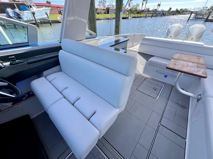 Impulse Yacht Photos Pics 2022 Aviara AV 32 Outboard boat interior with white seating and wooden table.
