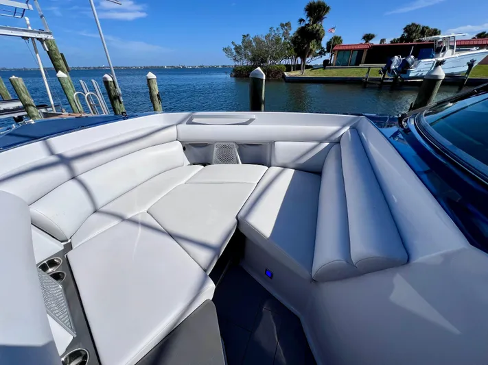 Impulse Yacht Photos Pics 2022 Aviara AV 32 Outboard boat with luxurious seating, docked by a scenic waterfront.
