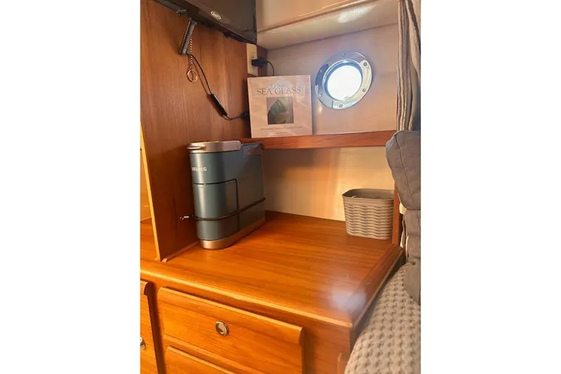 Sea Glass II Yacht Photos Pics 2024 Ranger Tugs R-27 Luxury Edition interior with wooden cabinetry and porthole window.