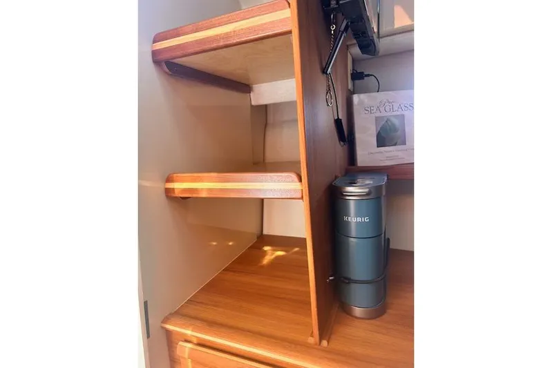 Sea Glass II Yacht Photos Pics 2024 Ranger Tugs R-27 Luxury Edition interior with wooden shelves and a Keurig coffee maker.