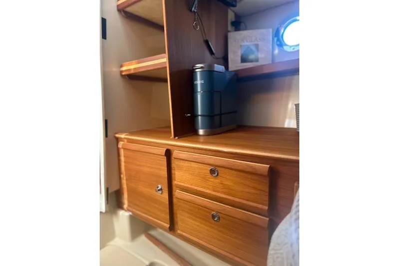 Sea Glass II Yacht Photos Pics 2024 Ranger Tugs R-27 Luxury Edition interior with wooden cabinetry and coffee maker.