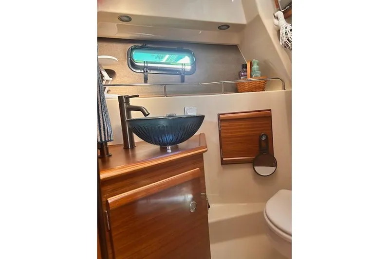 Sea Glass II Yacht Photos Pics 2024 Ranger Tugs R-27 Luxury Edition bathroom with modern sink and wooden cabinetry.
