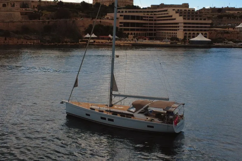 Gr Yacht Photos Pics 2017 Grand Soleil 52LC yacht sailing in a calm harbor with buildings in the background.