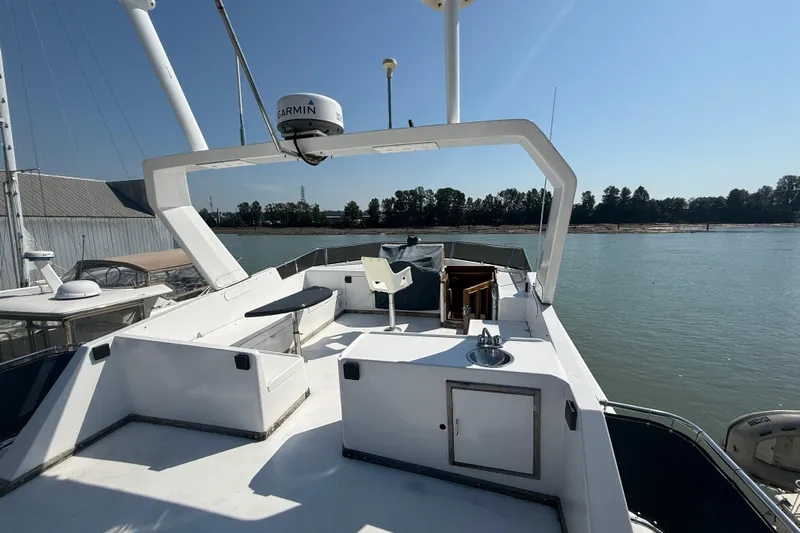 Qui-si-sana Yacht Photos Pics 1989 Jefferson 52 Victory yacht deck with seating, sink, and navigation equipment on a sunny day.
