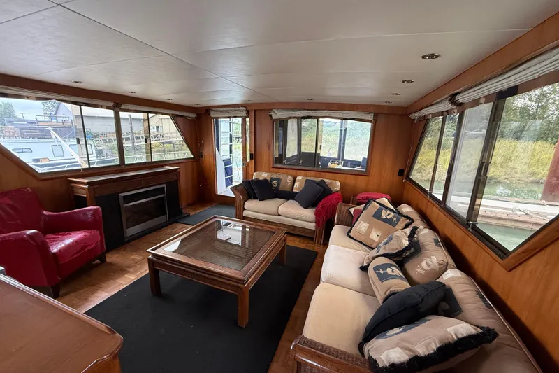 Qui-si-sana Yacht Photos Pics Luxurious interior of 1989 Jefferson 52 Victory yacht with cozy seating and large windows.