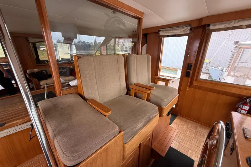 Qui-si-sana Yacht Photos Pics Interior of 1989 Jefferson 52 Victory yacht with cushioned seating and wooden accents.