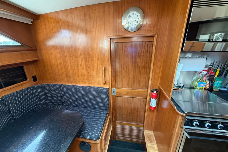 Qui-si-sana Yacht Photos Pics 1989 Jefferson 52 Victory yacht interior with wood paneling, kitchenette, and seating area.