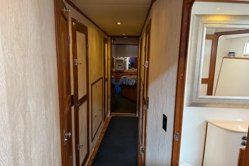 Qui-si-sana Yacht Photos Pics Hallway inside 1989 Jefferson 52 Victory yacht, featuring wooden doors and a mirror.