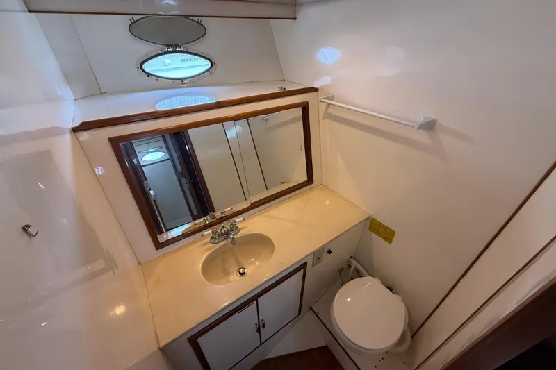 Qui-si-sana Yacht Photos Pics Bathroom interior of 1989 Jefferson 52 Victory yacht with sink, mirror, and toilet.
