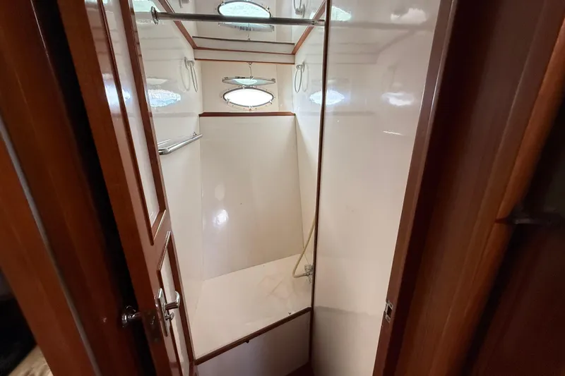 Qui-si-sana Yacht Photos Pics Shower area inside 1989 Jefferson 52 Victory yacht, featuring wooden trim and porthole window.