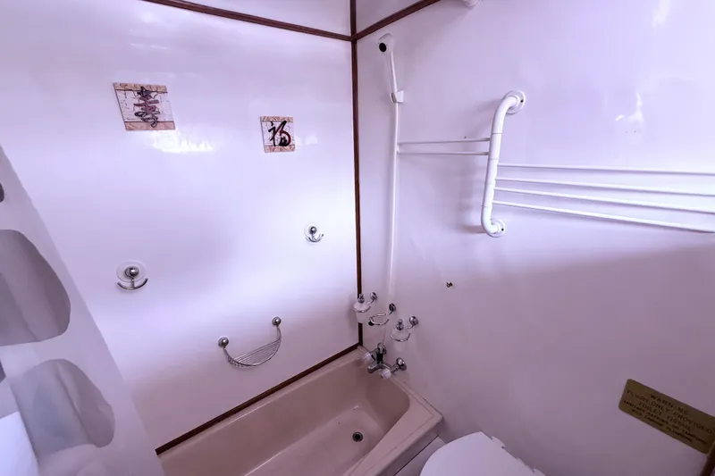 Qui-si-sana Yacht Photos Pics 1989 Jefferson 52 Victory bathroom with bathtub, shower, and towel rack.