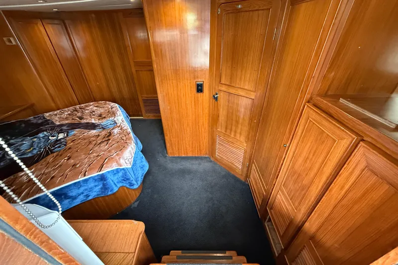 Qui-si-sana Yacht Photos Pics Cozy cabin interior of 1989 Jefferson 52 Victory yacht with wooden paneling and bed.