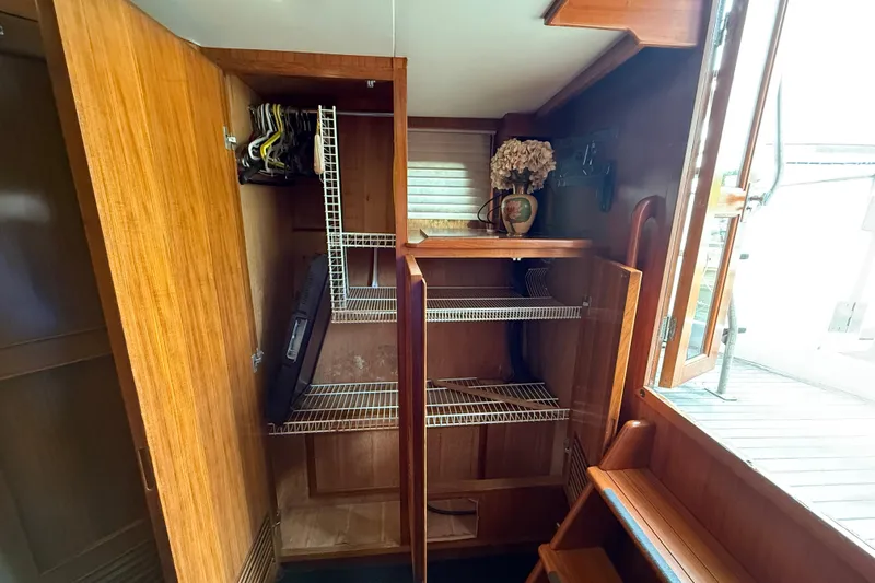 Qui-si-sana Yacht Photos Pics Wooden interior of 1989 Jefferson 52 Victory boat with open closet and shelves.